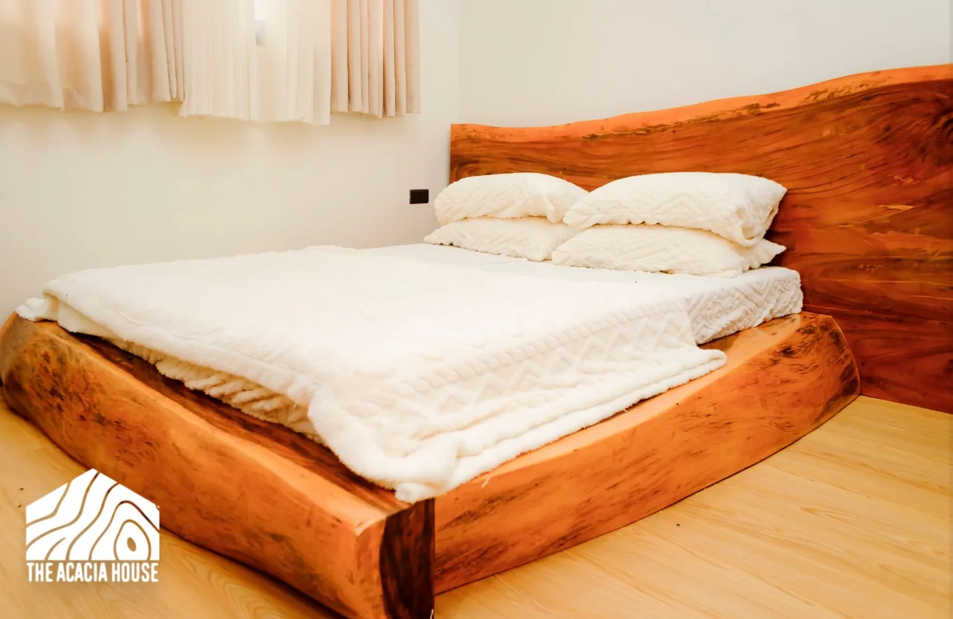 Bedroom with a solid live-edge wood bed frame and white bedding