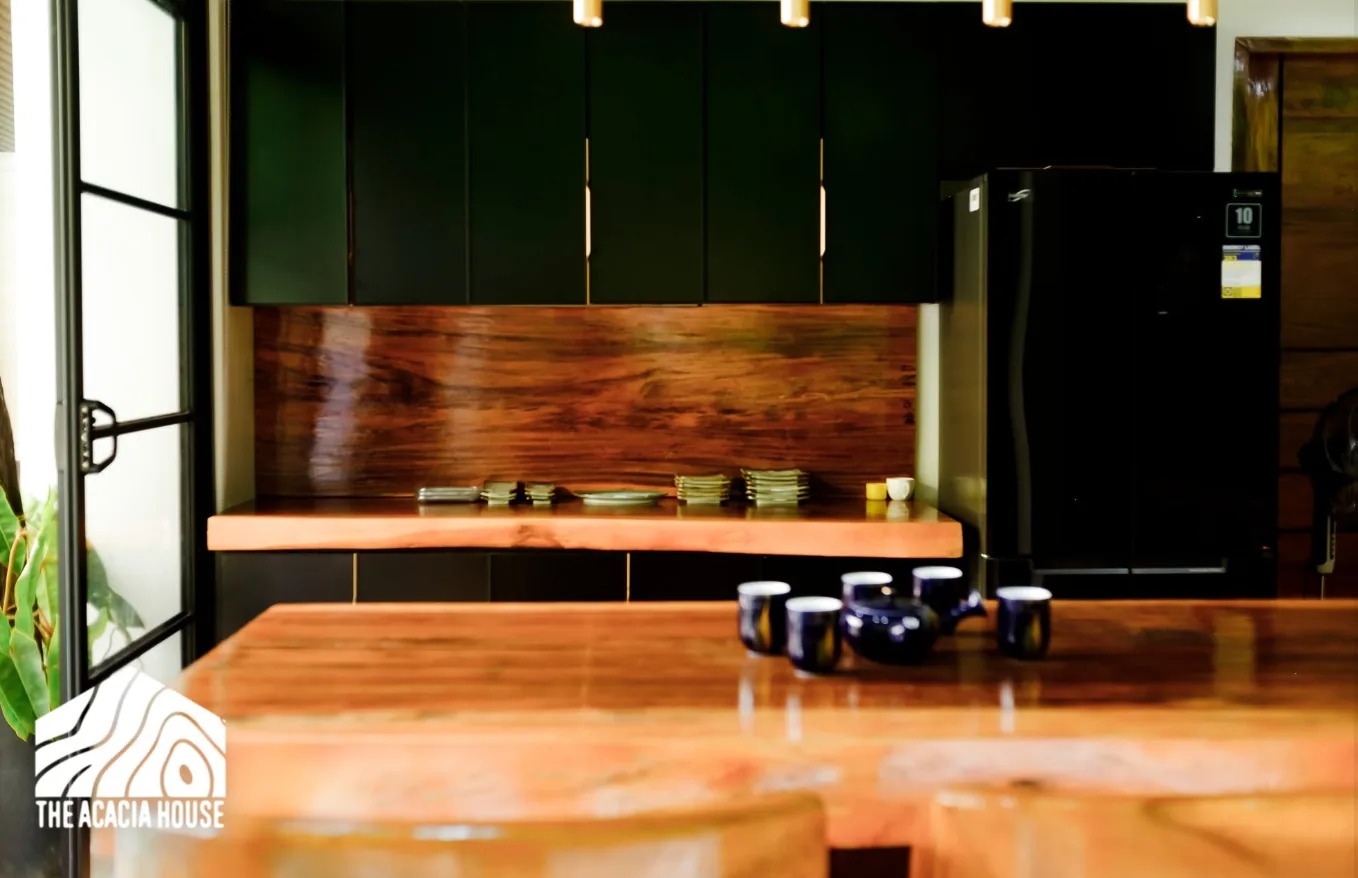 Kitchen with black cabinets, a wooden backsplash and a live-edge counter